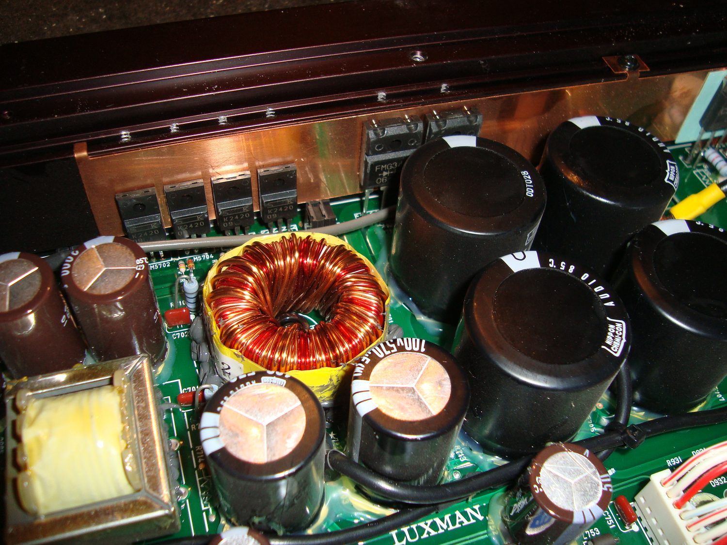 Внутренний вид DC-DC преобразователя Luxman CM-2100: тороидальный трансформатор, конденсаторы и медная шина